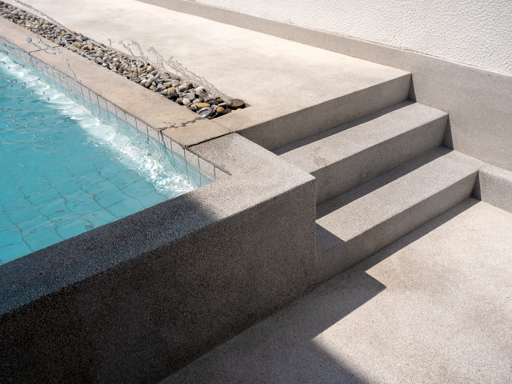 Piscine extérieure ovale à liner bleu dans jardin résidentiel paysagé