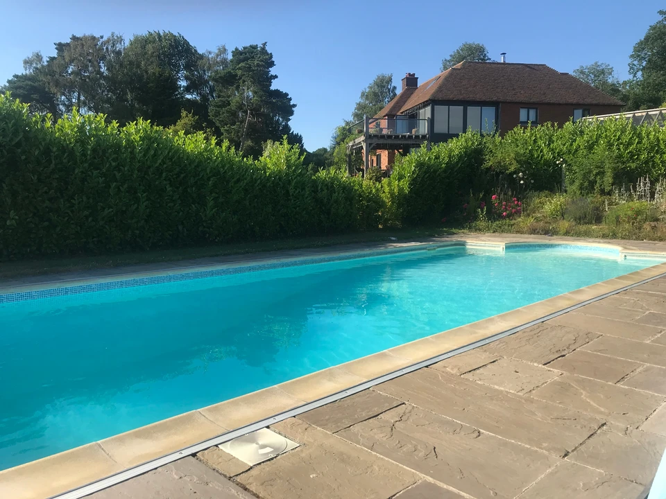 Vue aérienne d'un aménagement extérieur résidentiel avec piscine forme libre et spa circulaire intégré