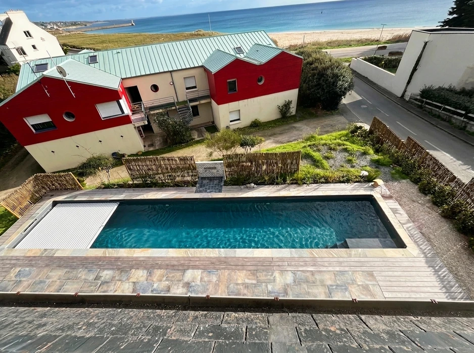Terrasse extérieure en dalles de pierre naturelle type ardoise ou schiste bleu-gris, posées en appareillage décalé