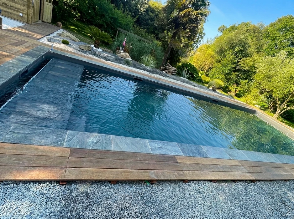 Terrasse extérieure en dalles de pierre naturelle type ardoise ou schiste bleu-gris, posées en appareillage décalé