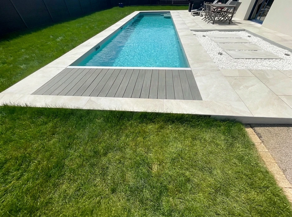 Terrasse extérieure en dalles de pierre naturelle type ardoise ou schiste bleu-gris, posées en appareillage décalé