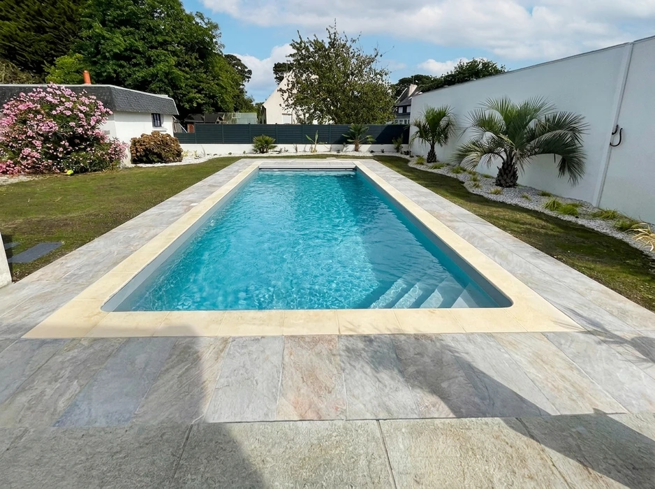 Terrasse extérieure en dalles de pierre naturelle type ardoise ou schiste bleu-gris, posées en appareillage décalé
