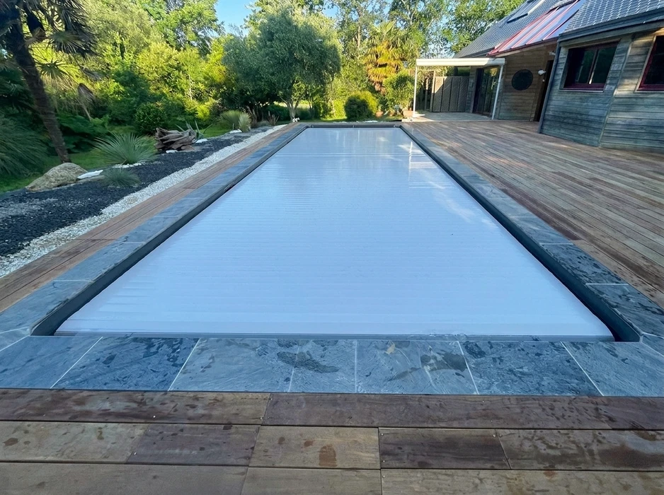Terrasse extérieure en dalles de pierre naturelle type ardoise ou schiste bleu-gris, posées en appareillage décalé
