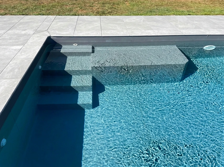 Terrasse extérieure en dalles de pierre naturelle type ardoise ou schiste bleu-gris, posées en appareillage décalé