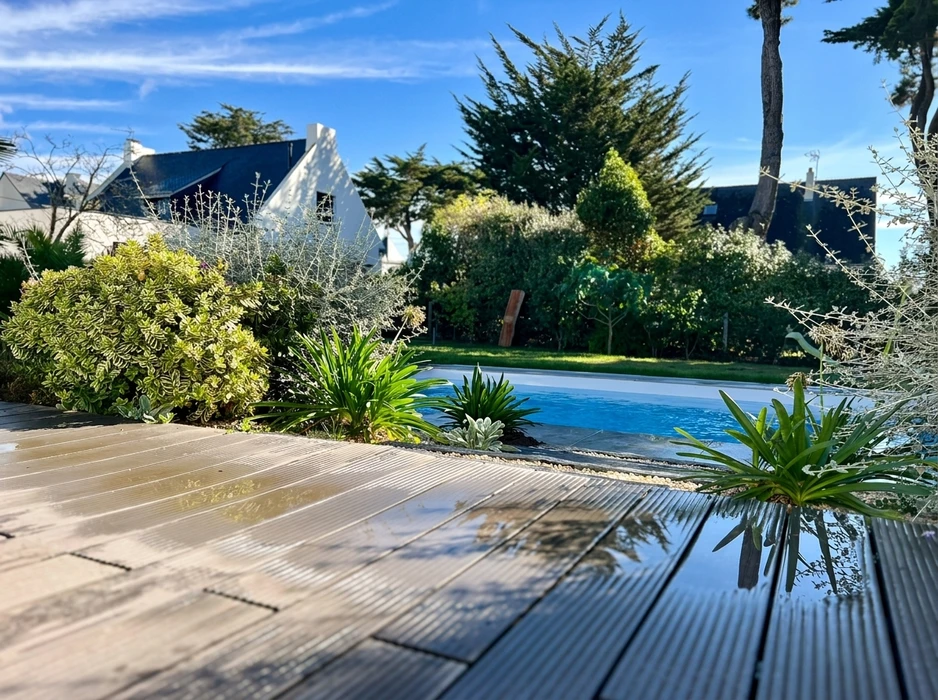 Terrasse extérieure en dalles de pierre naturelle type ardoise ou schiste bleu-gris, posées en appareillage décalé