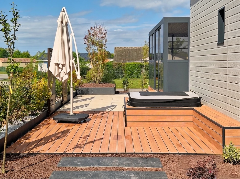 Terrasse extérieure en dalles de pierre naturelle type ardoise ou schiste bleu-gris, posées en appareillage décalé