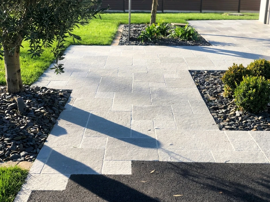 Terrasse extérieure en dalles de pierre naturelle type ardoise ou schiste bleu-gris, posées en appareillage décalé