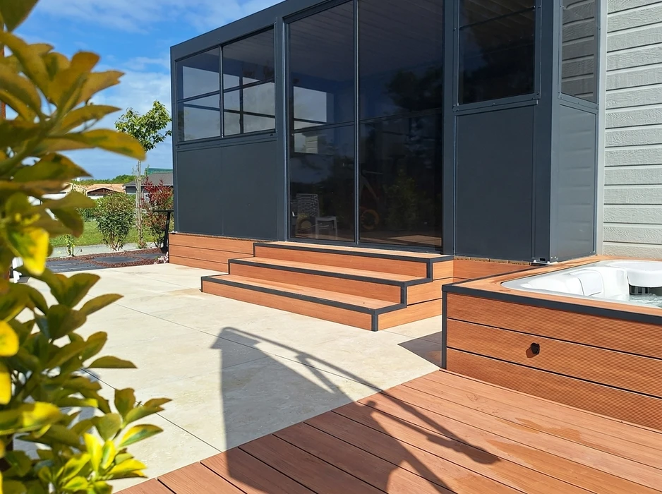 Terrasse extérieure en dalles de pierre naturelle type ardoise ou schiste bleu-gris, posées en appareillage décalé